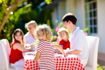 Family eating outdoor. Garden summer fun.