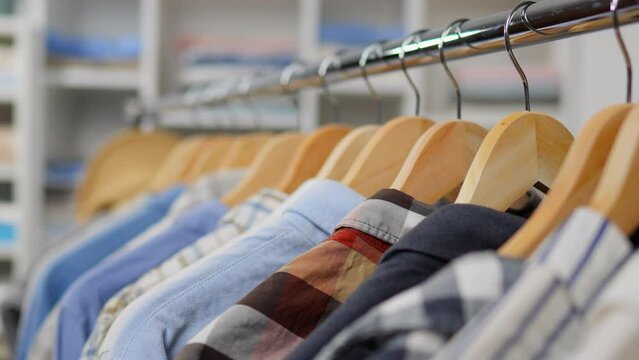 Small business, shirt hangers are weighed on a barbell rack. Warehouse of clothes shirts, Background from coat hangers for clothes. Multicolored clothing shirts are weighed on a rack in a store

