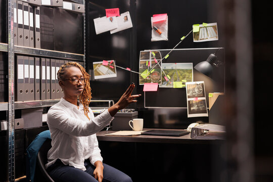 African american woman detective using ar technology in investigation. Police investigator searching insight, making evidence board and mindmapping with augmented reailty