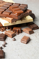Close up of several bars of melted white and dark chocolate on a stone top. High quality photo
