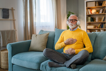 Mature senior man practice guided meditation manifestation at home