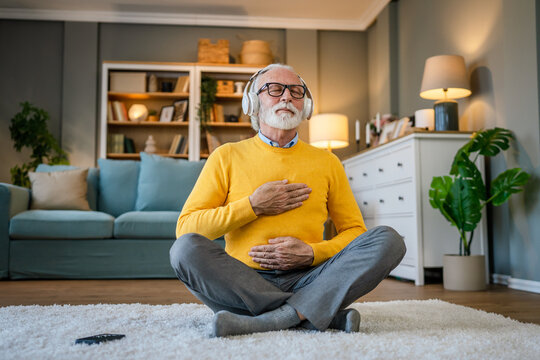 Mature senior man practice guided meditation manifestation at home