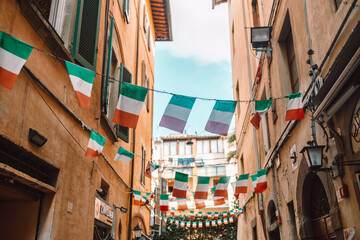 Holiday in the Italian city of streets with Italian flags and ancient buildings.Pisa, Italy.