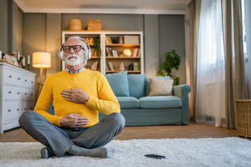 Mature senior man practice guided meditation manifestation at home - obrazy, fototapety, plakaty