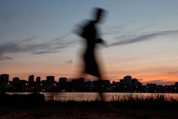 motion picture of person passing by the edge of the lagoon in the city of Rio de Janeiro at the end...