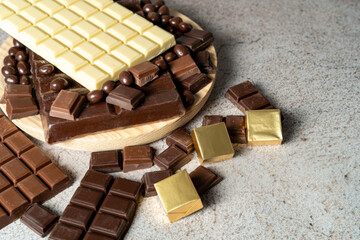 Close up of several bars of melted white and dark chocolate on a stone top. High quality photo