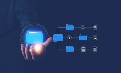 Hand holding file folder on virtual screen, Document management system (DMS) concept, Online documentation database and process to efficiently manage files, Managing corporate files.