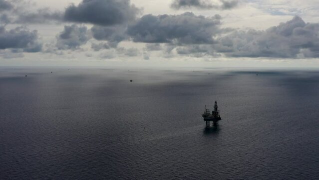 Jack up drilling rig and production platform in the middle of the ocean during couldy time
