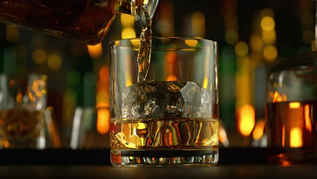Super Slow Motion Shot of Pouring Whiskey into Glass with Ice Cube at 1000fps with Camera Motion.