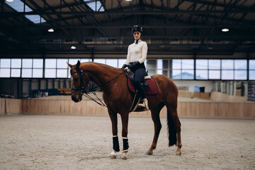 A young equestrian in uniform poses with a beautiful, majestic horse.