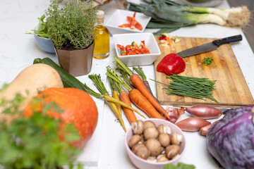 Close up of chopping board and knife with vegetables on countertop in kitchen