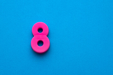 Number 8 color pink - Plastic piece on blue foamy background