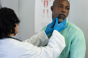 Biracial female doctor wearing medical gloves examinating african american male patient - Powered by Adobe