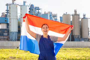 near large industrial enterprise in Netherlandish outback,jubilant female employee in work overalls...
