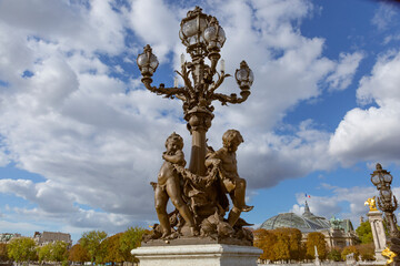 Fototapeta na wymiar Paris. Decorative street lamp on Pont Alexandre III, along River Seine. Grand Palais in background.