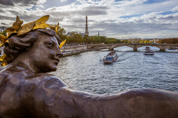 Fototapeta na wymiar Paris. Nymphes de la Seine statue on Pont Alexandre III, along River Seine. Distant Eiffel Tower.