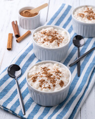Canjica or munguza, typical brazilian white corn sweet cream with cinnamon over wooden table