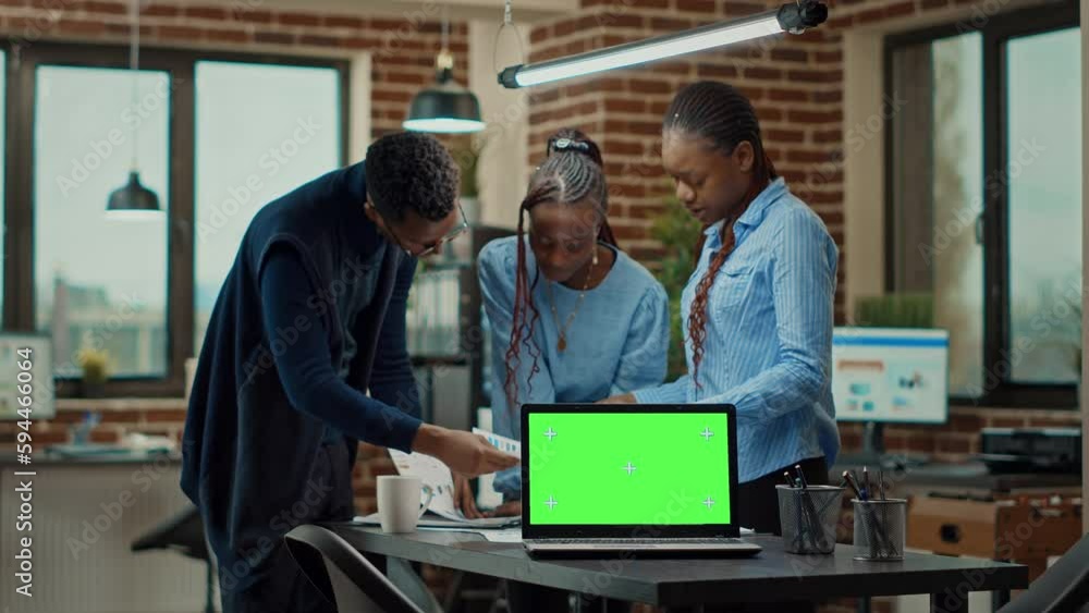 Poster workers having laptop with greenscreen, using blank mockup display to review annual data statistics 