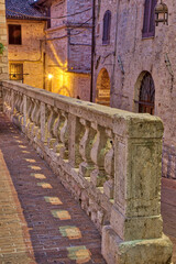 Fototapeta na wymiar Italy, Umbria, Assisi. Short stone wall with columns near the Convento Chiesa Nuova.