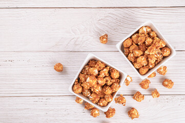 Top view of Caramel popcorn with candy on wood table background.