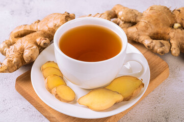 Cup of hot ginger tea white ginger root and slice 