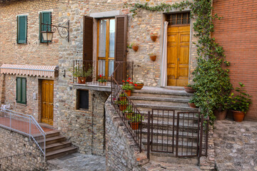 Fototapeta na wymiar Italy, Umbria. Stairs lined with flowering pots leading to homes in the historic town of Montone.