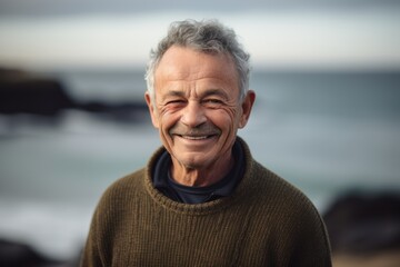 Group portrait photography of a grinning man in his 60s wearing a cozy sweater against a water or ocean background. Generative AI