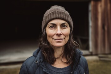 Portrait of smiling woman with hat and jacket in a rural area
