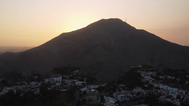 Ascending view of a backlit mountain to see the sun at sunset with a background of the horizon fading into the distance in South America, Lima, Peru. 