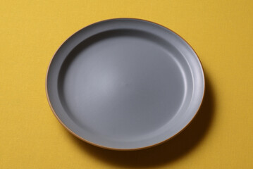 黄色い背景に置かれたグレーの皿