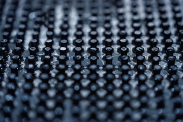 Close up of dark black peg repeating pattern