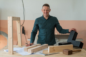 Carpenter holding a metal connector for wooden parts. 