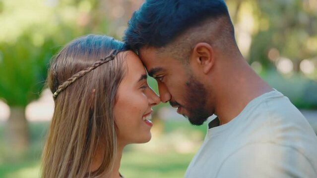Forehead touch, love and happy couple in park for bonding, quality time and relax on weekend date. Relationship, dating or interracial man and woman outdoors together for trust, commitment or romance