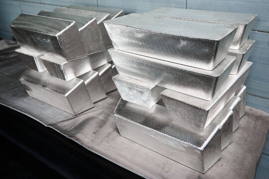 Stack of industrial silver ingots at bright light in storage