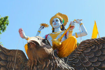 The Supreme God Vishnu with attributes of power in four hands flies astride Garuda. Hindu religious...