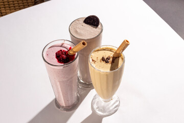 Glasses with delicious milkshakes with nuts, caramel, strawberry and whipped cream