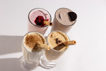 Glasses with delicious milkshakes with nuts, caramel, strawberry and whipped cream
