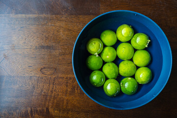 Blue Bowl Of Limes In Water