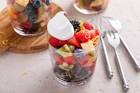 Fruit salad with berries and honey dressing served in a glass