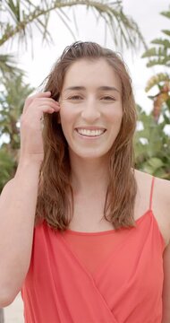 Vertical video of portrait of happy caucasian woman at beach house