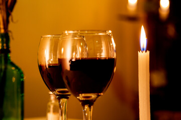 glass of red wine and candle in romantic place