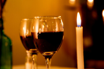 glass of red wine and candle in romantic place