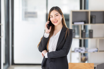 Lawyer business Asian woman office. Statue of Justice with scales and lawyer working on a laptop and using phone at workplace . Legal law, advice and justice concept.