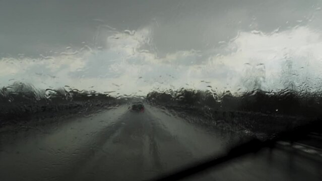POV through the windshield of a car on the highway in the middle of a cloudburst