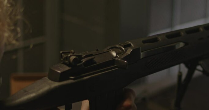 Close up of Ruger Mini 14 bolt. The rifle is being fired several times and spend shell casings get ejected in slow motion.