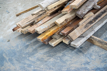 Bunch of old dusty wood laying on concrete floors for building construction materials