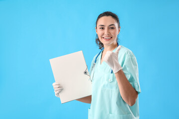 Female medical assistant with folder showing thumb-up on light blue background