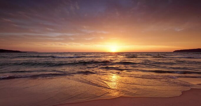 Tropical beach shore and golden sea sunrise over ripple water