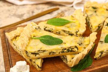 Board with pieces of delicious quiche on grey table
