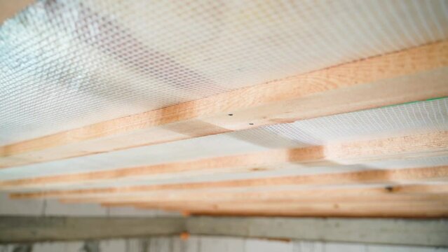 Vapor barrier film on the ceiling, close-up. Smooth camera movement